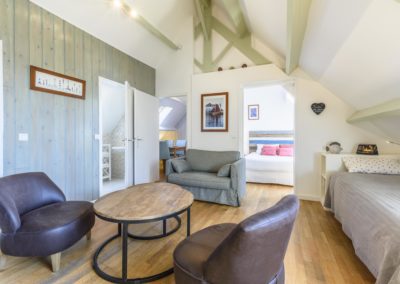 Chambre familiale avec 3 lits et un coin salon